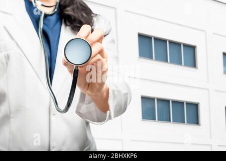 Ärztin mit Stethoskop außerhalb des Krankenhauses Stockfoto