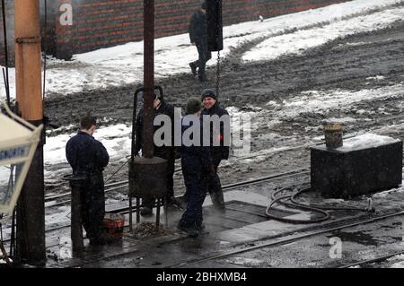 Das Personal hält sich warm durch den Feuerteufel im Hof von Bridgnorth. Stockfoto