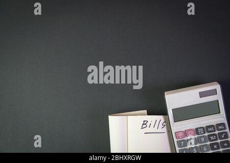 Rechnungen. Notizblock mit Rechner auf schwarzer Farbtabelle. Kopierbereich. Stockfoto