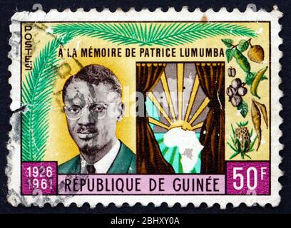 GUINEA - UM 1962: Eine in Guinea gedruckte Briefmarke zeigt Patrice Lumumba und die Karte von Afrika, Todestag von Patrice Lumumba, Premierminister des Kongo Stockfoto