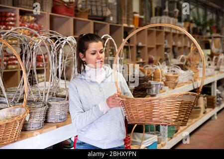 Positive Mädchen Wahl original dekorativen Weidenkörbe im Geschäft Stockfoto