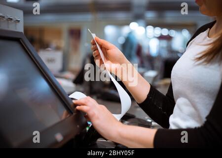 Verkäuferin, Kauffrau, die einen Beleg druckt, Rechnung für einen Kunden, Verkaufszeit, Rabattzeitraum, Finanzkonzept Stockfoto