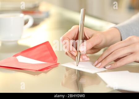 Nahaufnahme der Frau Hand Schreiben Gruß Dankeschön Karte sitzen auf einem Schreibtisch zu Hause Stockfoto
