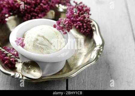 Schöne Komposition mit leckerem Eis und lila Blüten Stockfoto