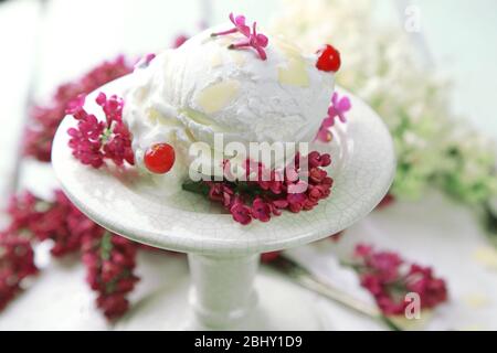 Schöne Komposition mit leckerem Eis und lila Blüten Stockfoto