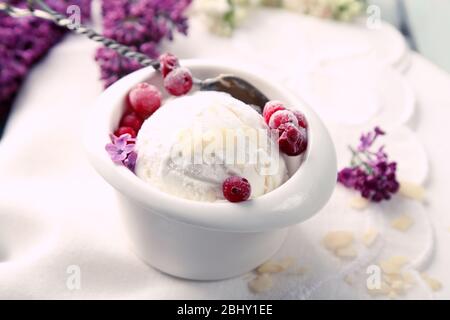 Schöne Komposition mit leckerem Eis und lila Blüten Stockfoto