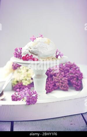 Schöne Komposition mit leckerem Eis und lila Blüten Stockfoto