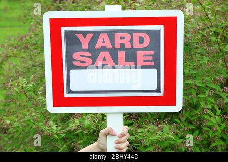 Holzhof Sale Schild in weibliche Hand über grünes Gras Hintergrund Stockfoto