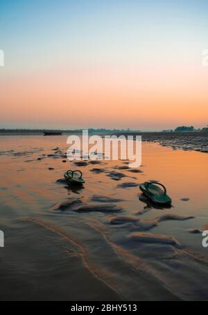 Fußabdrücke im Sand am Fluss Brahmaputra bei Sonnenuntergang. Stockfoto