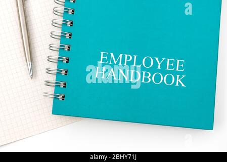 Mitarbeiterhandbuch oder Handbuch mit einem Stift und Papier auf einem weißen Tisch in einem Büro - Personalmanagement-Richtlinie, erläutert Geschäftsziele, Ergebnisse, definieren Stockfoto