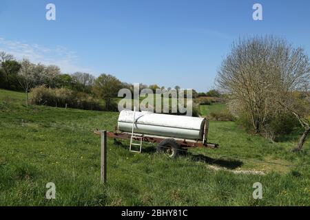 Mobile Wasserfass auf Rädern steht in einer Wiese Stockfoto