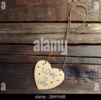 Schriftliche Nachricht auf Herz aus Pappe auf Holzhintergrund Stockfoto
