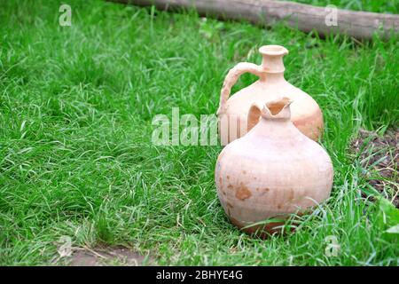 Alte Tonkrüge auf grünem Gras Hintergrund Stockfoto