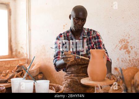 Professionelle afrikanischer amerikanischer Mann potter Malerei Keramik Topf in der Töpferei Stockfoto