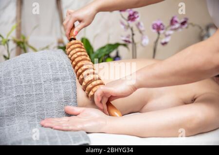 Nahaufnahme der Maderotherapie-Antizelluliti-Massage mit Holzrollenmassagegerät Stockfoto