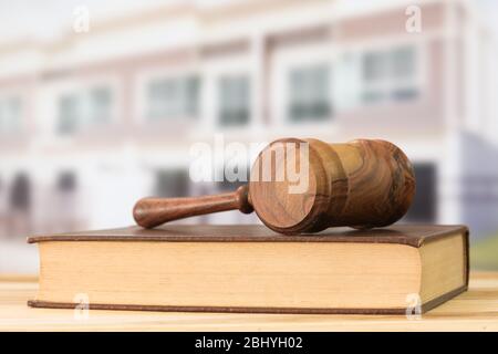 Gavel, Gesetzbücher mit Gebäude im Hintergrund. Baurechtliche Konzeption. Stockfoto