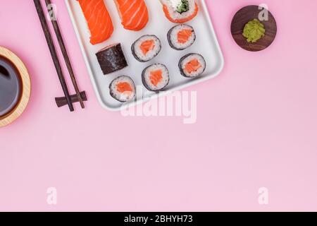Sushi-Set mit Salmin auf rosa Hintergrund, Draufsicht. Stockfoto