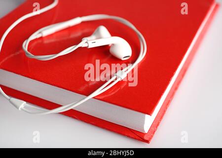 Kopfhörer und Buch auf dem Tisch, Nahaufnahme Stockfoto