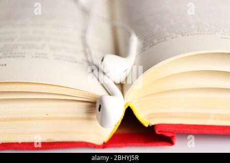 Kopfhörer und Buch auf dem Tisch, Nahaufnahme Stockfoto