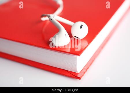 Kopfhörer und Buch auf dem Tisch, Nahaufnahme Stockfoto