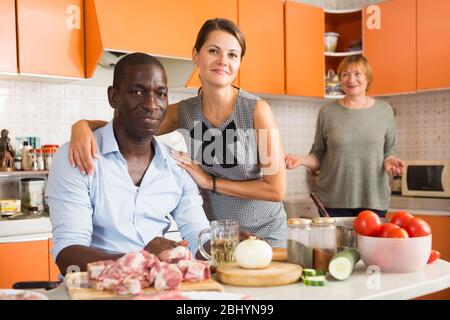 Glücklich interracial paar genießen Zeit zusammen zu Hause, posiert in gemütlicher Küche Stockfoto