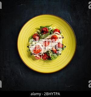 Köstlicher Caprese-Salat mit reifen Tomaten und Mozzarella-Käse, flacher Lay Shot, dunkler Hintergrund Stockfoto