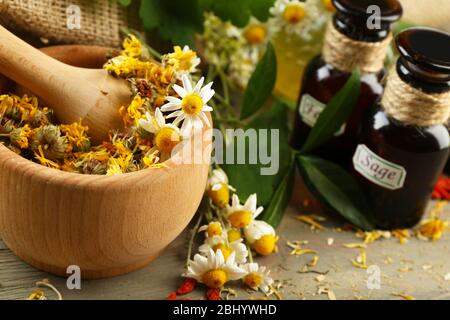 Kräuter, Beeren und Blumen mit Mörtel, Holz Tisch Hintergrund Stockfoto