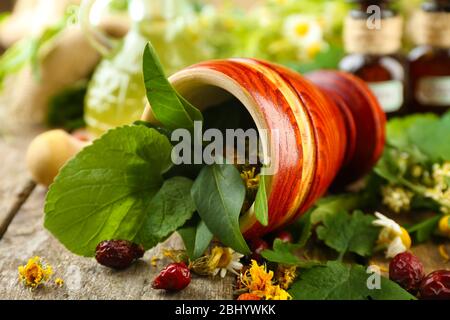 Kräuter, Beeren und Blumen mit Mörtel, Holz Tisch Hintergrund Stockfoto