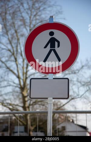 Ein rundes Straßenschild in Weiß und Rot mit einem schwarzen Mann in der Mitte: Keine Fußgänger dürfen weiterfahren. Zusätzliches Schild mit Kopierfläche Stockfoto