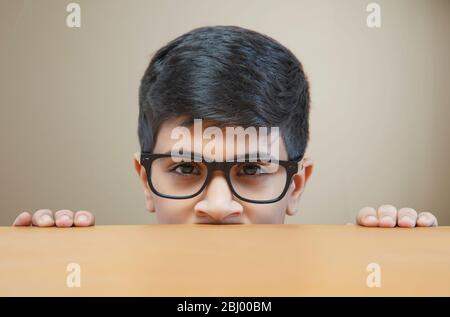 Porträt des guckenden Jungen trägt eine Brille Stockfoto