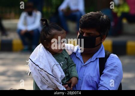 Prayagraj, Indien. April 2020. Ein gestrandeter Student mit seinem Kind wartet auf den Bus, als die Regierung Uttar Pradesh Straßenbusse arrangierte, um Studenten in ihre Heimatstadt zu schicken, während die Regierung als vorbeugende Maßnahme gegen die COVID-19 in Prayagraj landesweite Lockdown verhängte. (Foto von Prabhat Kumar Verma/Pacific Press) Quelle: Pacific Press Agency/Alamy Live News Stockfoto