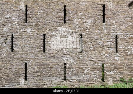 Lüftungsschlitze in der Wand einer alten Steinscheune, Herefordshire, Großbritannien Stockfoto