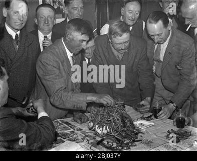 Bezahlen Sie in der Nacht im Rat und Sparrow Club in Eynsford, Kent. - Männer untersuchen den Stapel der Rattenschwänze auf dem Tisch. Mitglieder erhalten entsprechend der Anzahl der Rattenschwänze in ihrem Fang bezahlt. - 1939 Stockfoto