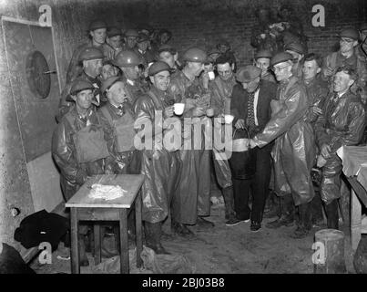 ARP ( Air RAID Vorsichtsmaßnahmen ) Arbeiter entspannen in ihren Gas Kontamination Anzüge . Hier nehmen sie den "Becher, der jubelt". - 1939 Stockfoto