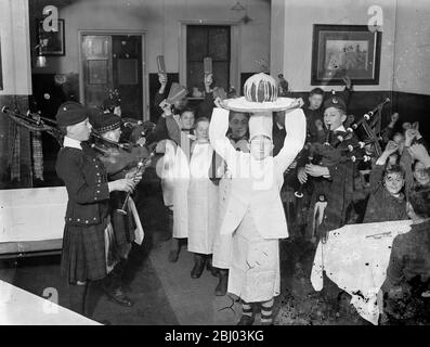 Weihnachtsfeiern haben bereits in einem Barnardo Hause begonnen. - die Weihnachtsfeierlichkeiten haben einen frühen Start in Dr. Barnardo ' s Dalziel von Wooler Memorial Home, Kingston, wo die Weihnachts-Puddings wurden in mit aufwendigen Zeremonie Piped gemacht. - Foto zeigt, Jungs jubeln als Weihnachtspudding kommen in voller Insignie. - 30. November 1935 Stockfoto