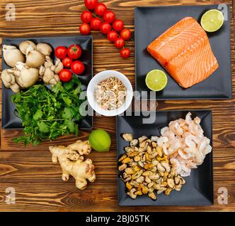 Frische Meeresfrüchte, Gemüse und Pilze auf Holzhintergrund Stockfoto