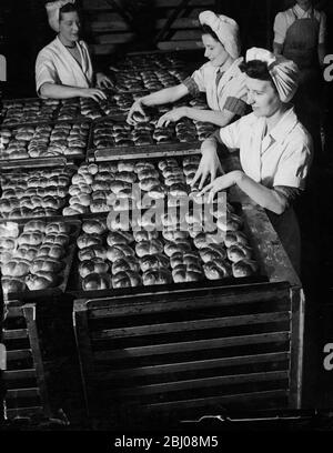 Die Mädchenarbeiter der Cadby Hall-Bäckereien von J Lyons und Co. Bereiten einen Teil der riesigen Anzahl von heißen Brötchen vor, die am Karfreitag gebacken wurden. In diesem Jahr der Brotrationierung sind sie zum ersten Mal heiße Kreuzbrötchen. - 3. April 1947 Stockfoto