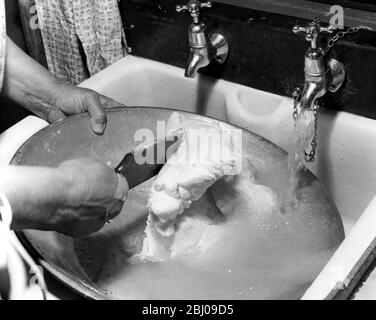 Miss Peggy Macleod spült die Schüssel aus, nachdem sie Butter von Hand in Daliburgh South Uist Outer Hebridges Scotland gemacht hat - September 1961 Stockfoto