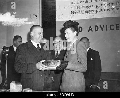 Die Rt. Sir Ben Smith, K.B.E., M.P., Minister für Ernährung, eröffnete die Ausstellung "Battle for Bread" auf dem bombardierten Gelände von John Lewis. - das Bild zeigt Sir Ben Smith und Dr. Edith Summerskill, M.P., Parlamentarische Staatssektion für das Lebensmittelministerium, die einen der New Economy Brote in der Ausstellung untersuchen. - 1. Mai 1946 Stockfoto