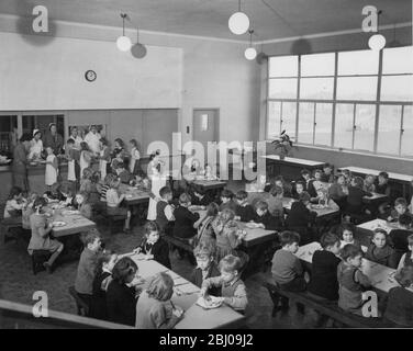 Mittags in der Schule, die Kinder Schlange geduldig mit ihren Tabletts, um ihre Mahlzeiten von den Abendessen Damen zu bekommen. - 4. Februar 1952 Stockfoto