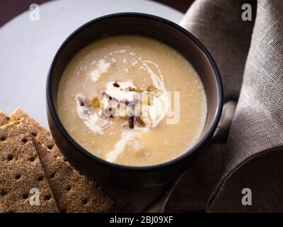 Sellerie und Blauschimmelkäse Suppe mit Beilage aus gebratenem Pancetta und Äpfeln Stockfoto