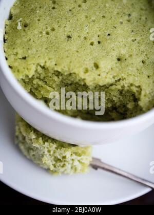 Köstliche einfache Kuchen mit gemahlenen Mandeln und Matcha Grüntee-Pulver, in einer Tasse in einer Mikrowelle gebacken. Stockfoto