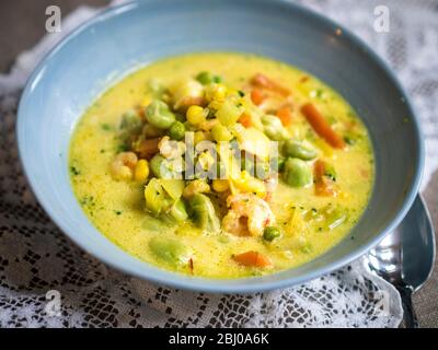 Schnelle und einfache Suppe/Eintopf von Gemüse mit Kabeljau-Stücken und Garnelen in safranduftender Brühe Stockfoto