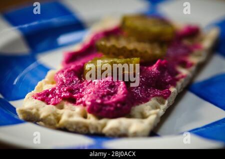 Bunte Gemüsepastete mit Bieroot, gekrönt mit Scheiben Dill eingelegte Gurken auf Knäckebrot Stockfoto