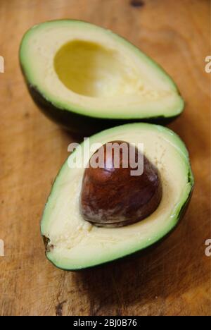 Ganze und schneiden frische Avocadobirne auf Holzhintergrund - Stockfoto