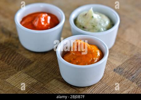 Kleine Töpfe mit handelsüblichen Saucen, die zum Verglaßen von Meaat vor dem Grillen verwendet werden. Kann auch als Relish verwendet werden - Stockfoto