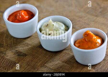 Kleine Töpfe mit handelsüblichen Saucen, die zum Verglaßen von Meaat vor dem Grillen verwendet werden. Kann auch als Relish verwendet werden - Stockfoto