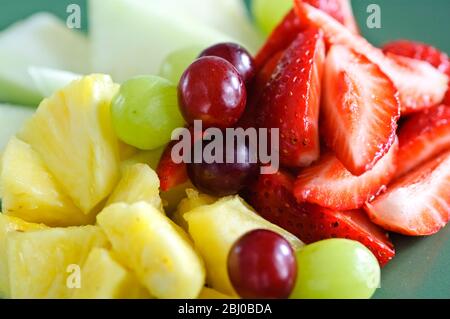 Frischer Obstsalat auf grünem Teller - Stockfoto