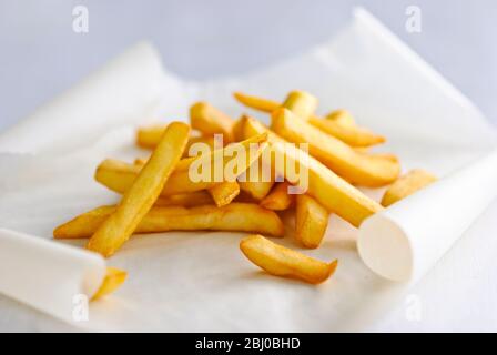 Stapel pommes frites auf fettdichtem Papier - Stockfoto