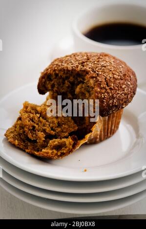 Zimtschnecken-Kleie Muffin auf weißen Tellern mit einer Tasse schwarzen Kaffee - Stockfoto